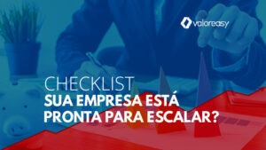 Pessoa à mesa do escritório analisando dados. Cones indicando crescimento e um cofrinho