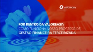 Mão de homem segurando um dardo sobre um alvo na mesa, ao lado de um teclado