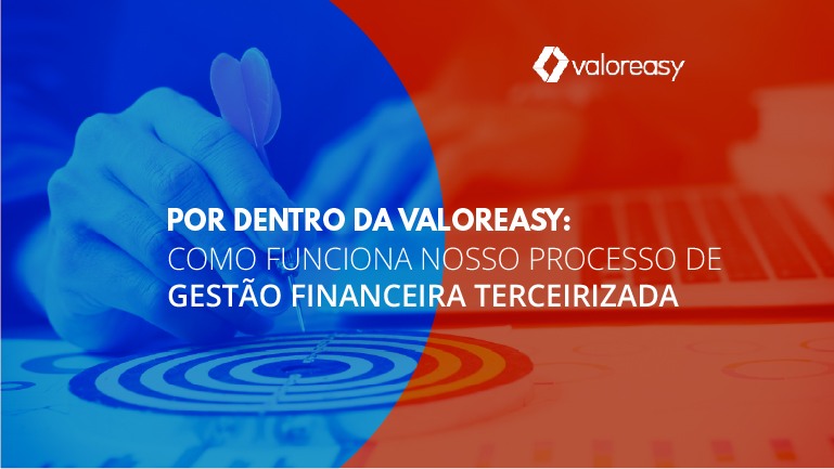 Mão de homem segurando um dardo sobre um alvo na mesa, ao lado de um teclado